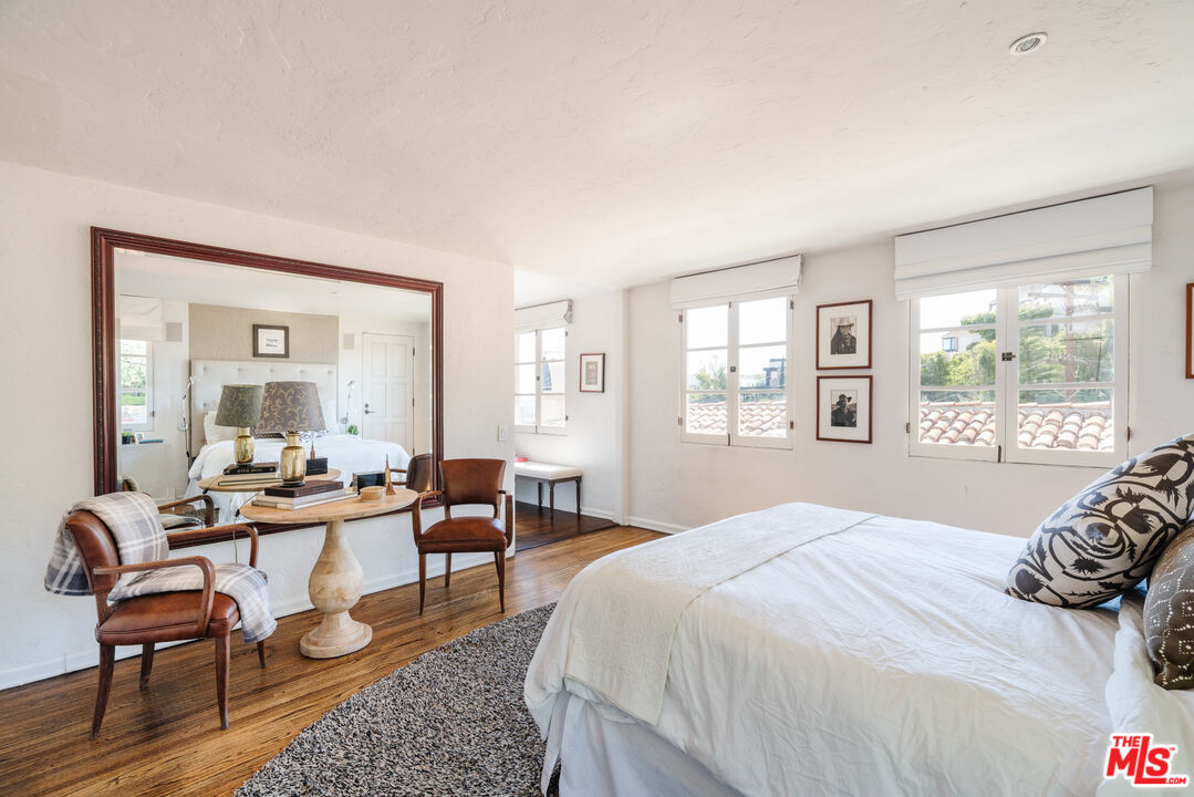 8430 Cresthill Road Los Angeles, CA 90069 - Photo 25 of 36 a bedroom with a bed and wooden floor