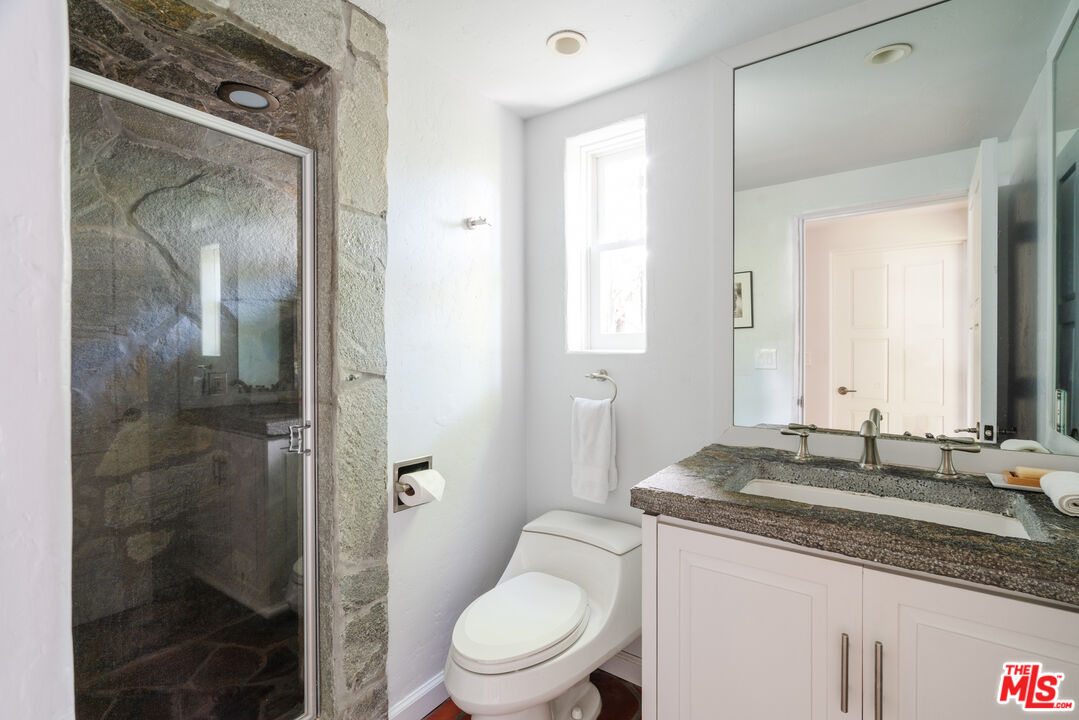 8430 Cresthill Road Los Angeles, CA 90069 - Photo 31 of 36 a bathroom with a granite countertop sink toilet and shower