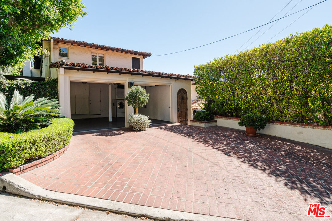 8430 Cresthill Road Los Angeles, CA 90069 - Photo 32 of 36 a front view of a house with a yard and garage