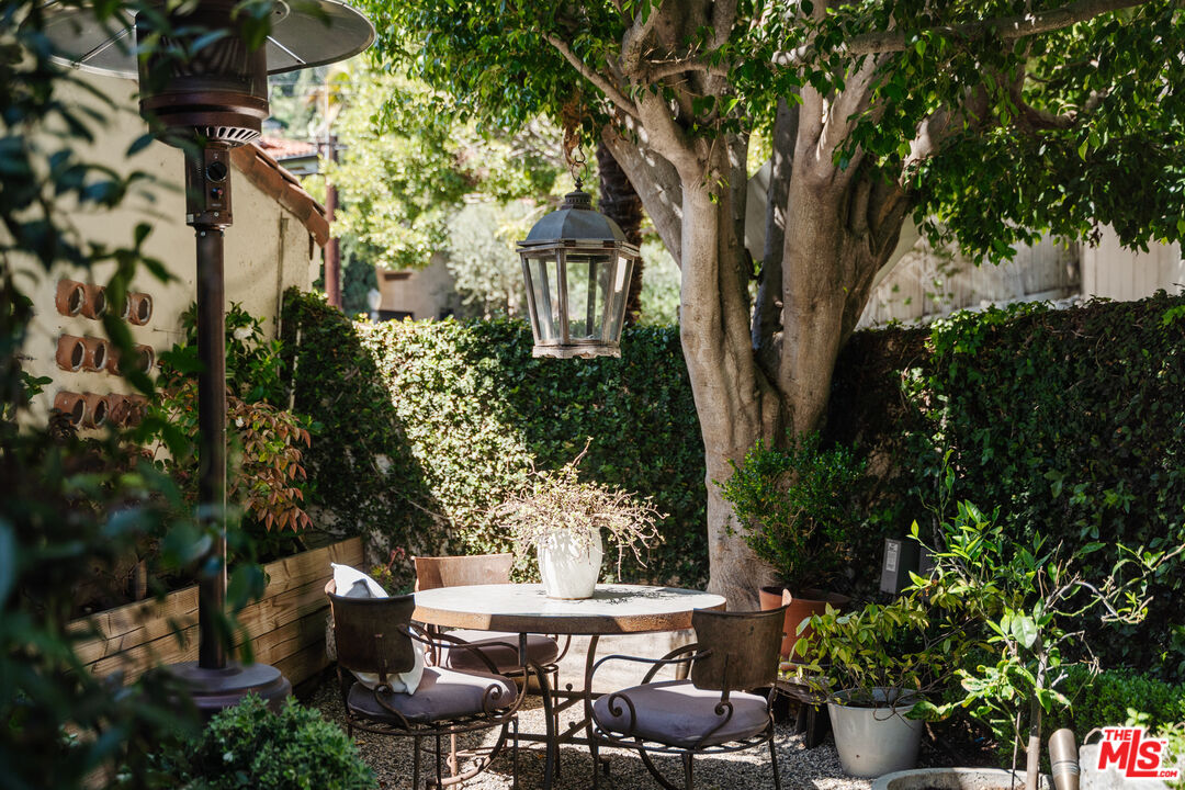 8430 Cresthill Road Los Angeles, CA 90069 - Photo 7 of 36 a view of a patio with table and chairs potted plants and large tree