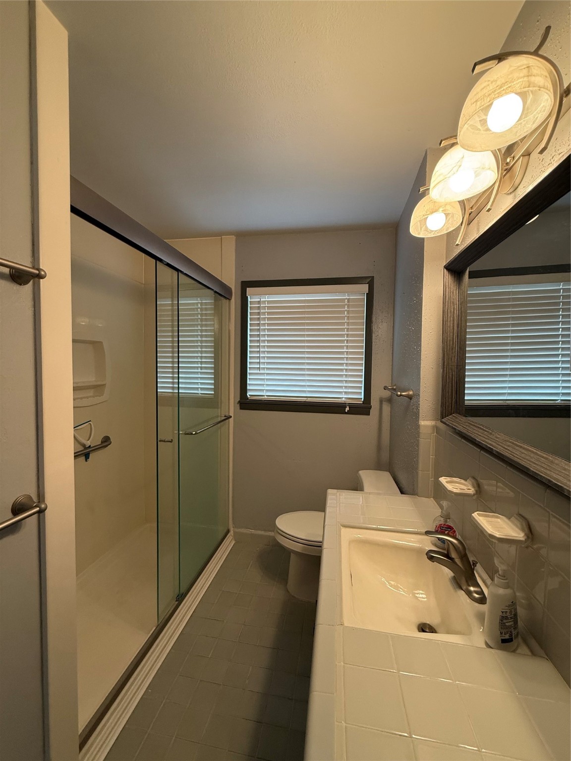 7945 Cedel Drive Houston, TX 77055 - Photo 10 of 11 a bathroom with a sink mirror and a shower