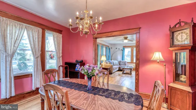 a view of a dining room with furniture a chandelier and wooden floor