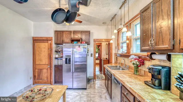 a kitchen with stainless steel appliances granite countertop a sink dishwasher stove and refrigerator