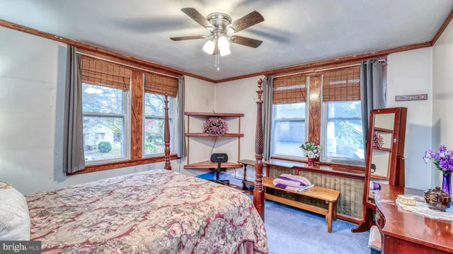 a bedroom with a bed and large windows