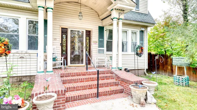 a view of a house with a small yard and wooden floor and fence