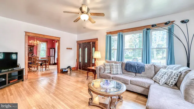 a living room with furniture a flat screen tv and a large window