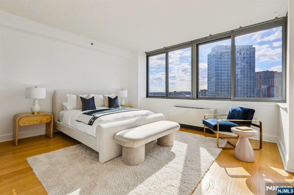 1 Spring Street, Unit 1004 New Brunswick, NJ 08901 - Photo 13 of 26 a bedroom with a bed and wooden floor