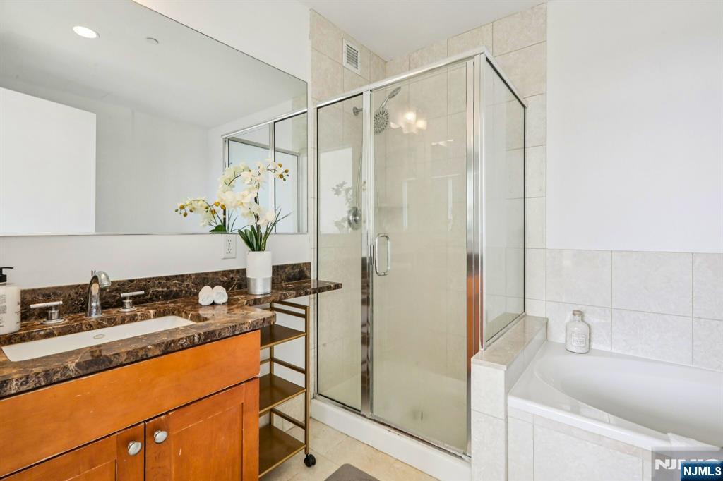 1 Spring Street, Unit 1004 New Brunswick, NJ 08901 - Photo 15 of 26 a bathroom with a granite countertop sink a mirror and a shower