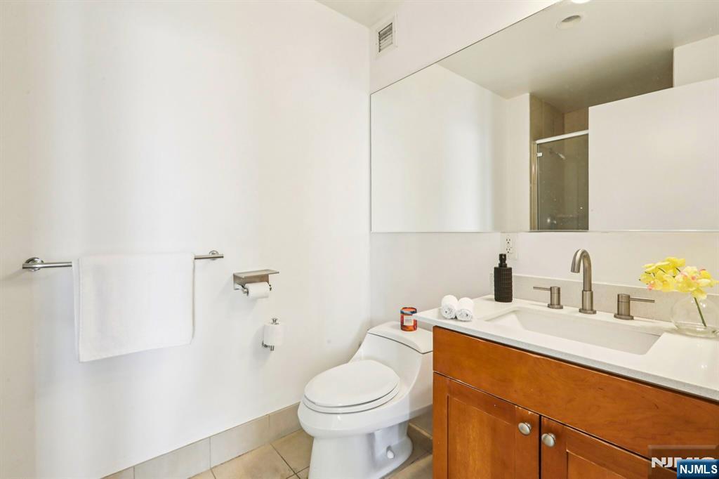 1 Spring Street, Unit 1004 New Brunswick, NJ 08901 - Photo 17 of 26 a bathroom with a sink toilet and a mirror
