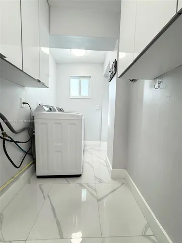 a bathroom with a granite countertop sink a washer and dryer