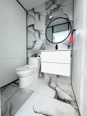 a bathroom with a sink toilet and a mirror