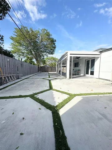 a view of a house with backyard and trees