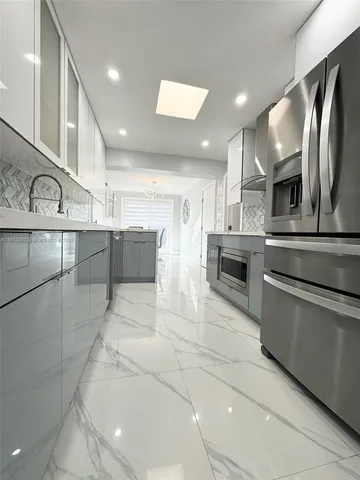 a kitchen with stainless steel appliances granite countertop a refrigerator and a stove top oven