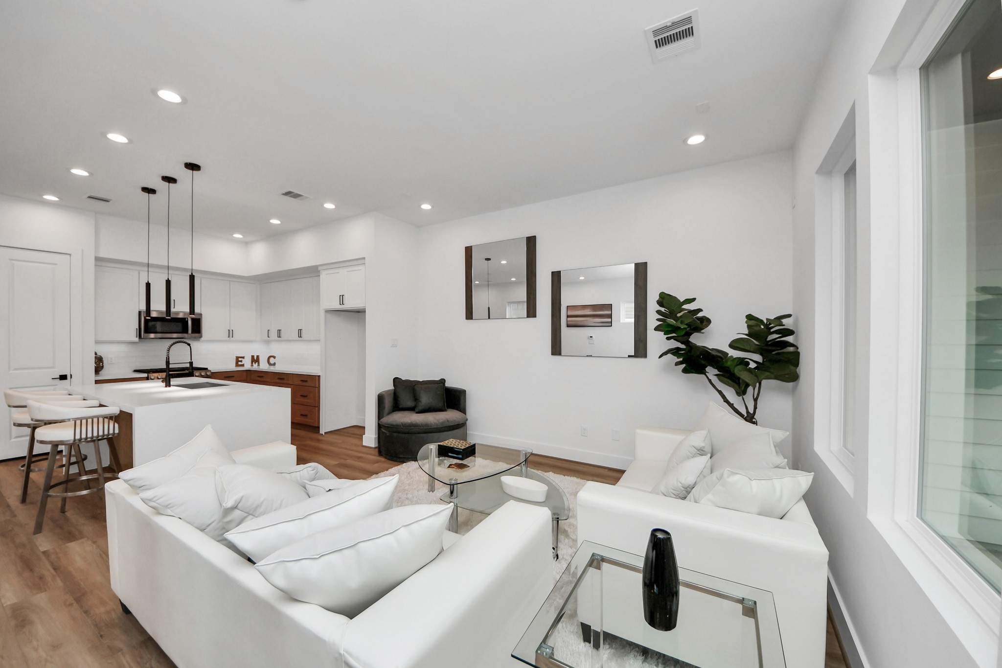505 Middle Street Houston, TX 77003 - Photo 13 of 46 Experience modern elegance in this inviting living room, featuring sleek white walls, a cozy seating area, and seamless flow into a stylish kitchen, perfect for entertaining and relaxing.