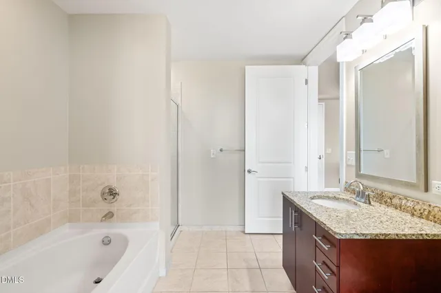 a bathroom with a granite countertop sink a mirror and a bathtub
