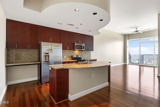 a kitchen with granite countertop stainless steel appliances a stove top oven a sink and dishwasher