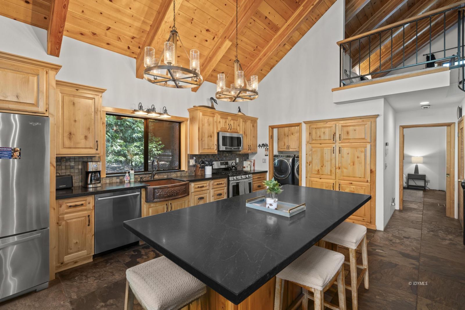 24747 Fern Valley Road Idyllwild, CA 92549 - Photo 12 of 42 a kitchen with a dining table chairs stainless steel appliances and cabinets