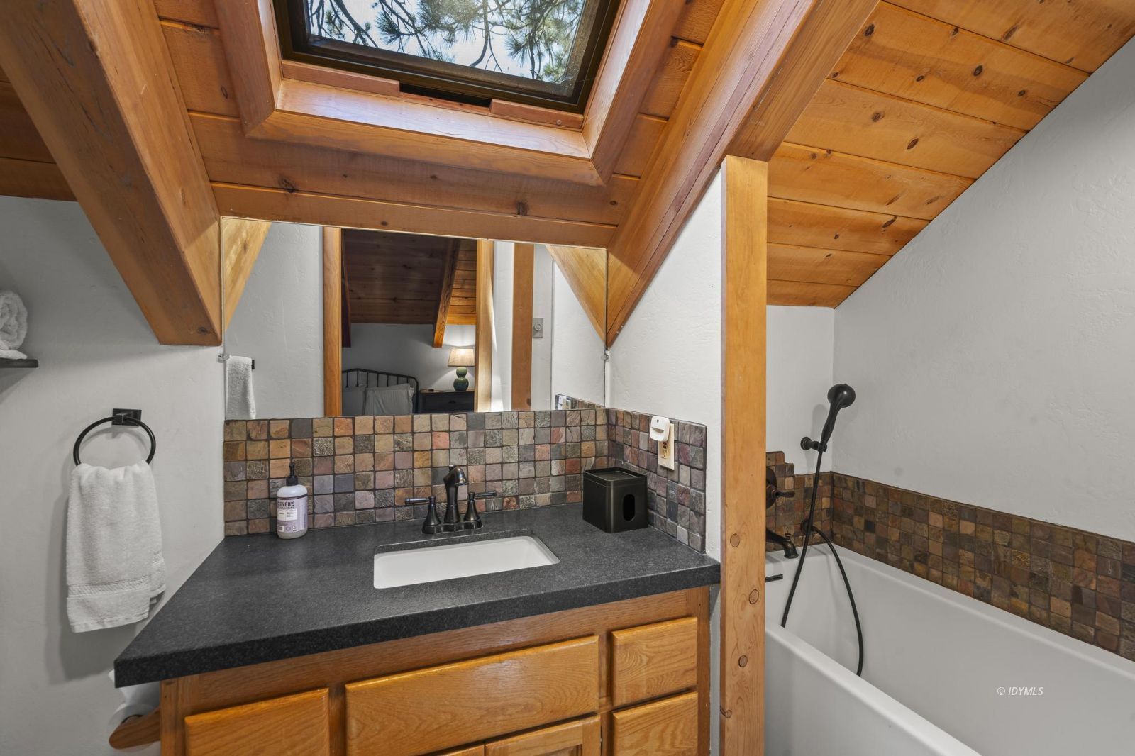 24747 Fern Valley Road Idyllwild, CA 92549 - Photo 20 of 42 a bathroom with a granite countertop sink and a bathtub