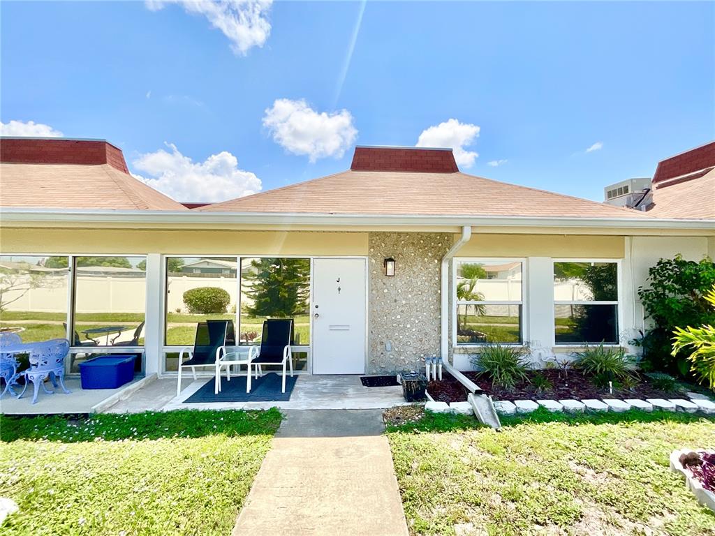 a view of a patio with table and chairs potted plants and floor to ceiling window