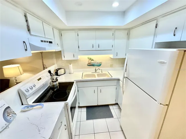 a kitchen with a sink a stove and cabinets