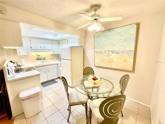 a kitchen with kitchen island a stove a sink and white cabinets with wooden floor