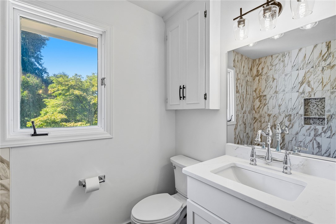 208 Williamsburg Road Anderson, SC 29621 - Photo 25 of 48 Lustrous stone counters and a marble-tiled shower wall frame this updated bathroom space.