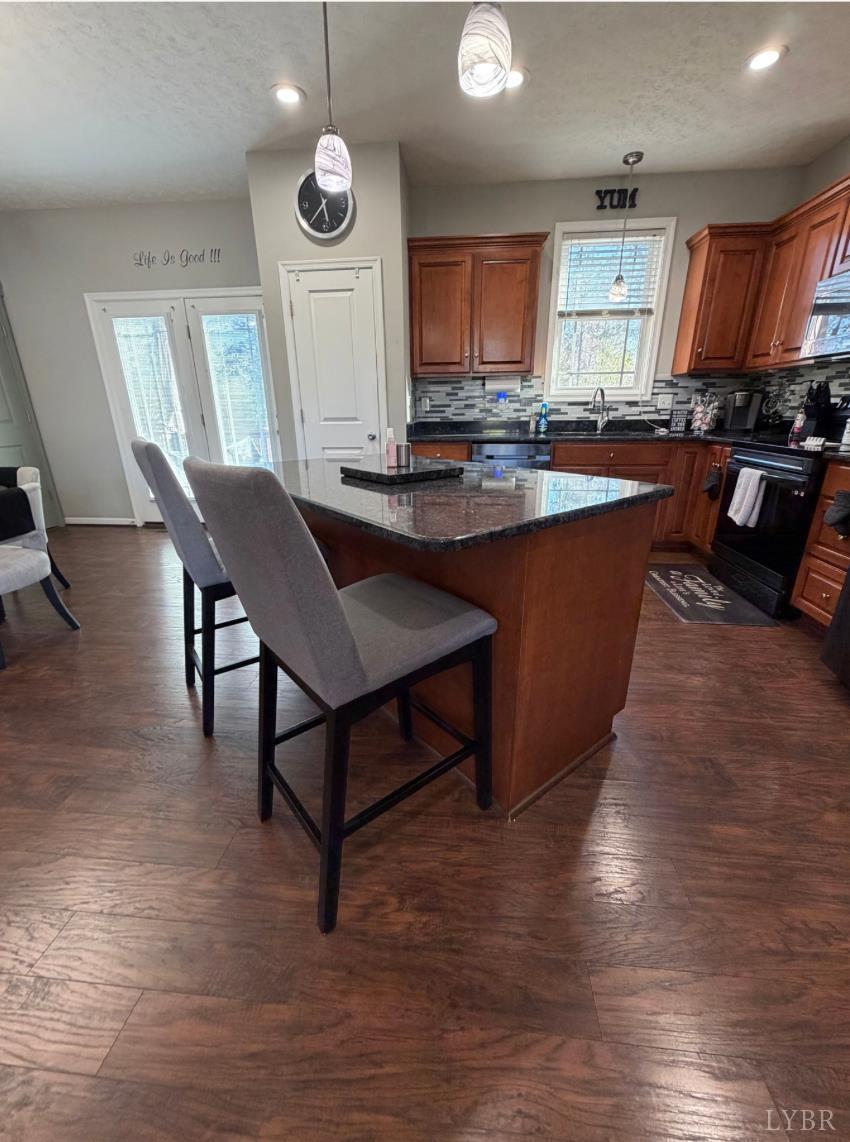 271 Pleasant Ridge Drive Madison Heights, VA 24572 - Photo 12 of 52 a kitchen with stainless steel appliances granite countertop a stove a sink dishwasher a microwave oven and a dining table with wooden floor