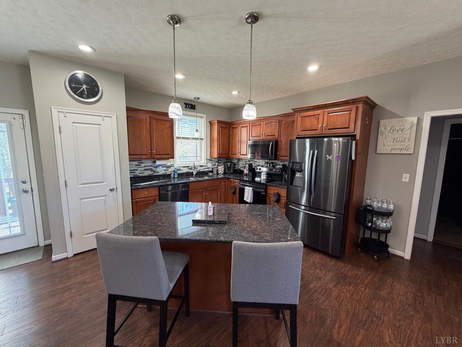 271 Pleasant Ridge Drive Madison Heights, VA 24572 - Photo 7 of 52 a kitchen with stainless steel appliances granite countertop a refrigerator a stove a sink a dining table and chairs with wooden floor