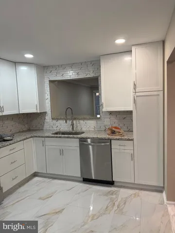 a bathroom with a granite countertop sink toilet mirror vanity and bathtub