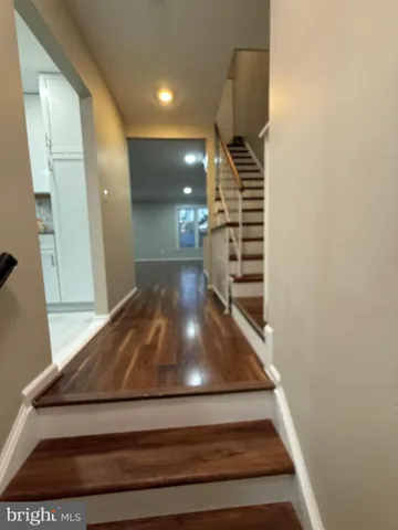 a view of staircase with wooden floor and white walls