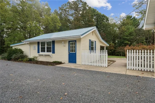 a view of a house with a yard and fence
