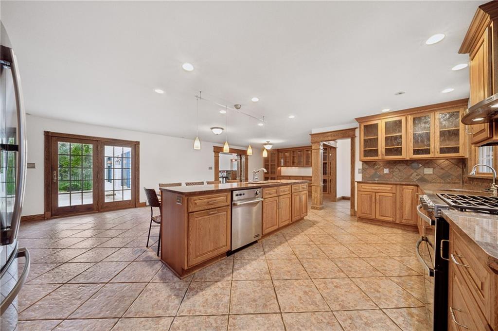 2 Deerfield Lane Indiana, PA 15701 - Photo 5 of 45 a large kitchen with stainless steel appliances granite countertop a stove top oven a sink dishwasher a dining table and chairs with wooden floor