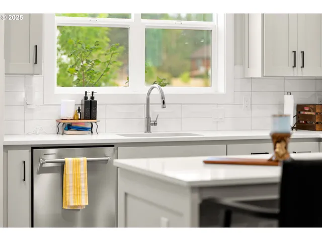 a kitchen with stainless steel appliances a stove and white cabinets