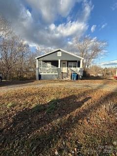 a view of a house with a big yard and large trees