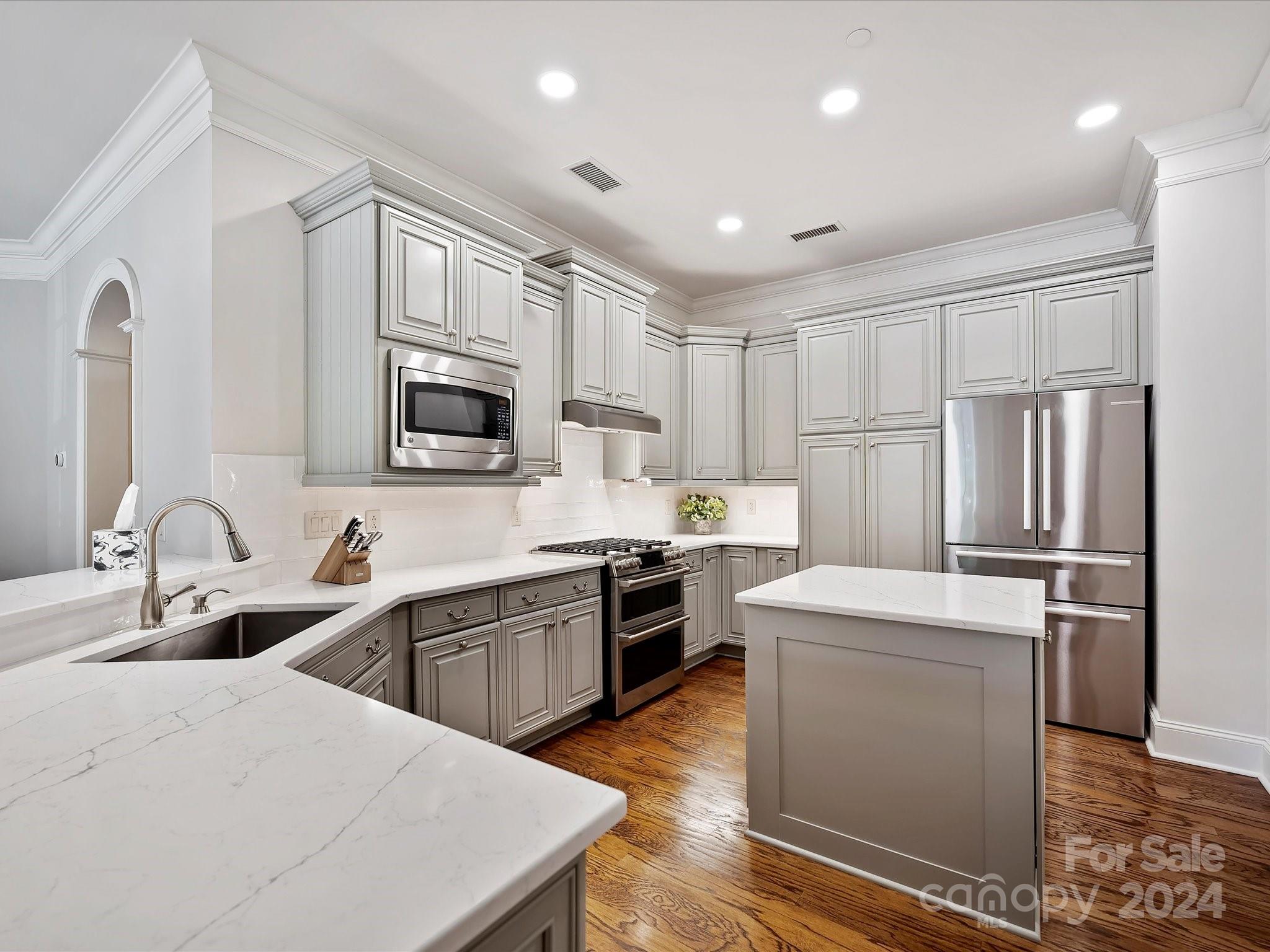 2823 Providence Road, Unit 216 Charlotte, NC 28211 - Photo 13 of 35 a kitchen with white cabinets and stainless steel appliances