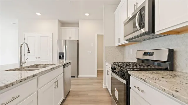 a kitchen with stainless steel appliances granite countertop a sink stove and refrigerator