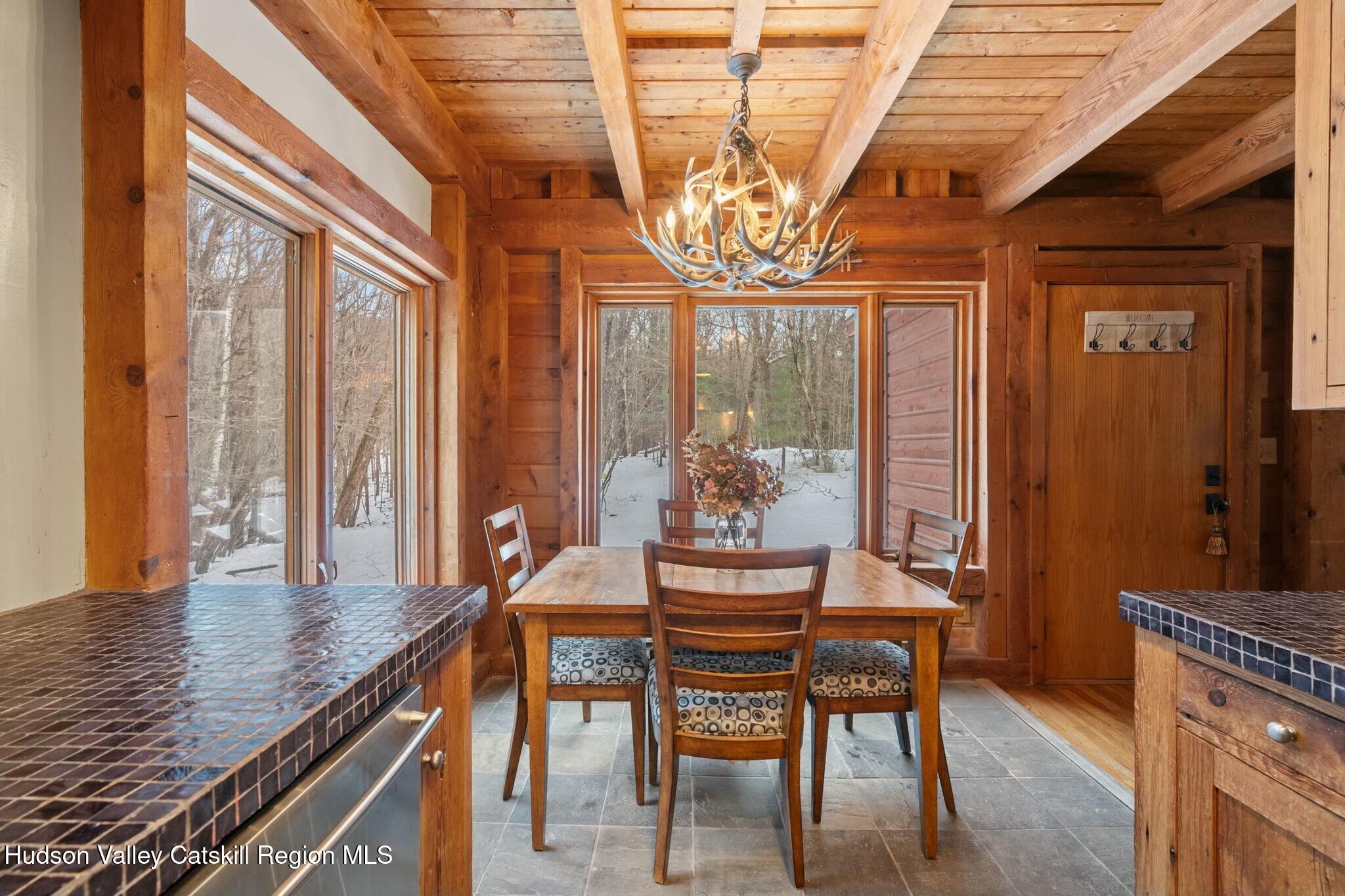 250 Macdaniel Road Woodstock, NY 12498 - Photo 14 of 39 a dining room with furniture a chandelier and wooden floor