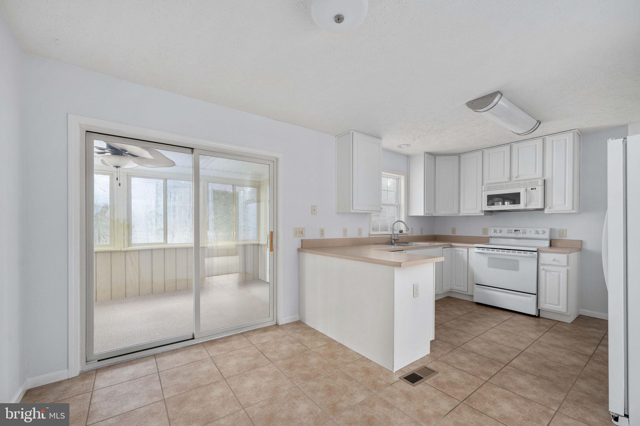 67 Stern Way Montross, VA 22520 - Photo 20 of 74 a kitchen with white cabinets and white appliances