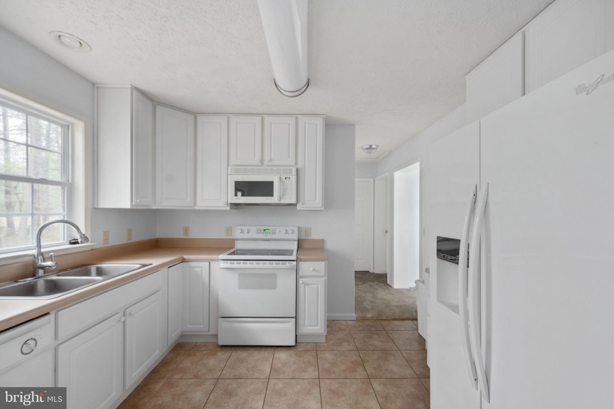 67 Stern Way Montross, VA 22520 - Photo 25 of 74 a kitchen with a sink a refrigerator and cabinets