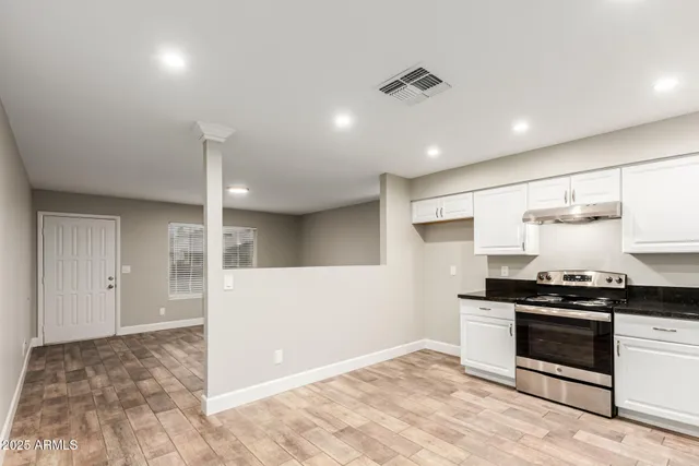 a kitchen with stainless steel appliances granite countertop a stove a refrigerator and a sink