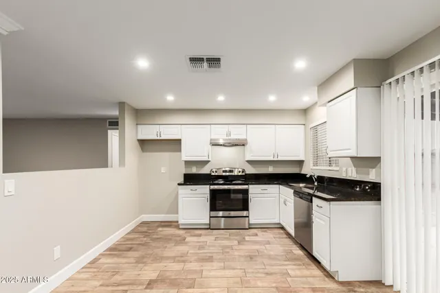 a kitchen with stainless steel appliances granite countertop a stove a sink and a refrigerator