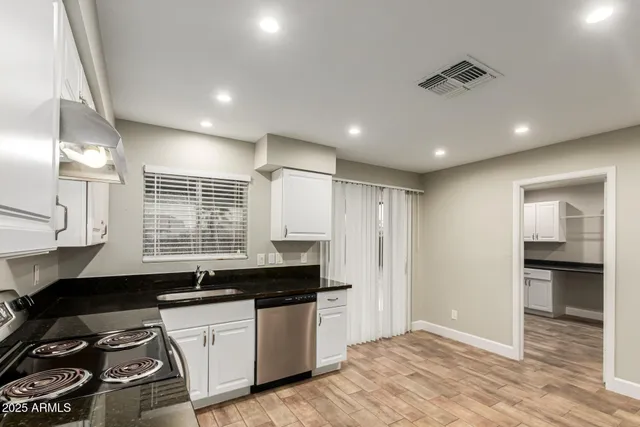 a kitchen with granite countertop a stove and a sink
