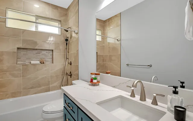 a bathroom with a sink a toilet and shower