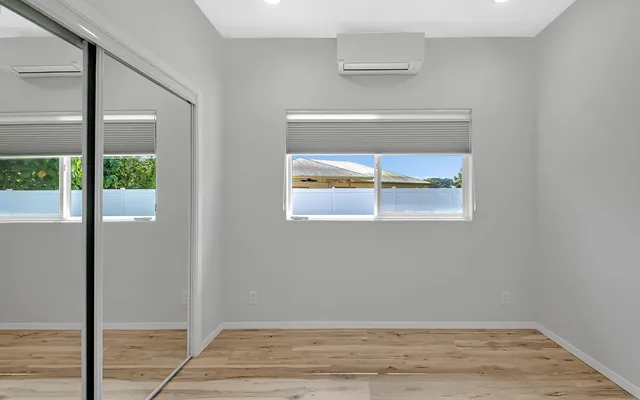a view of a small space with wooden floor and a window