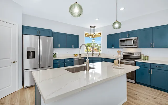 a kitchen with stainless steel appliances granite countertop a sink refrigerator and microwave