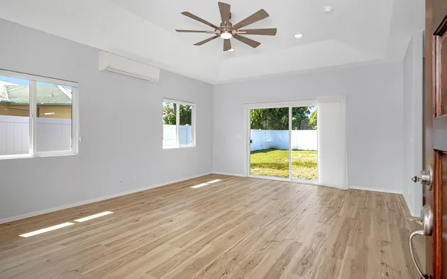 an empty room with a window and a ceiling fan