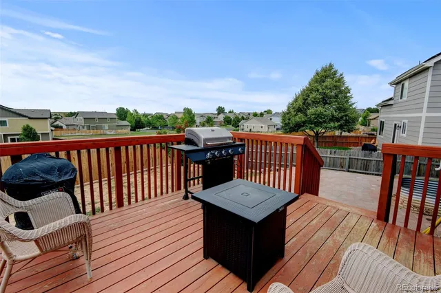 a view of a house with a yard chairs and wooden fence