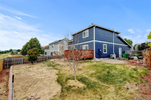a view of a backyard with wooden fence