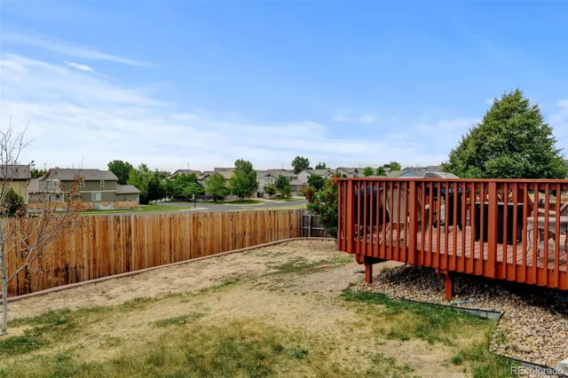 a view of a yard with wooden fence