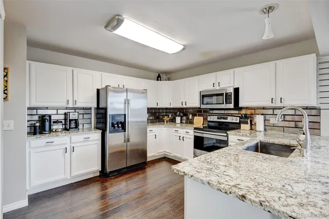 a kitchen with white cabinets and stainless steel appliances